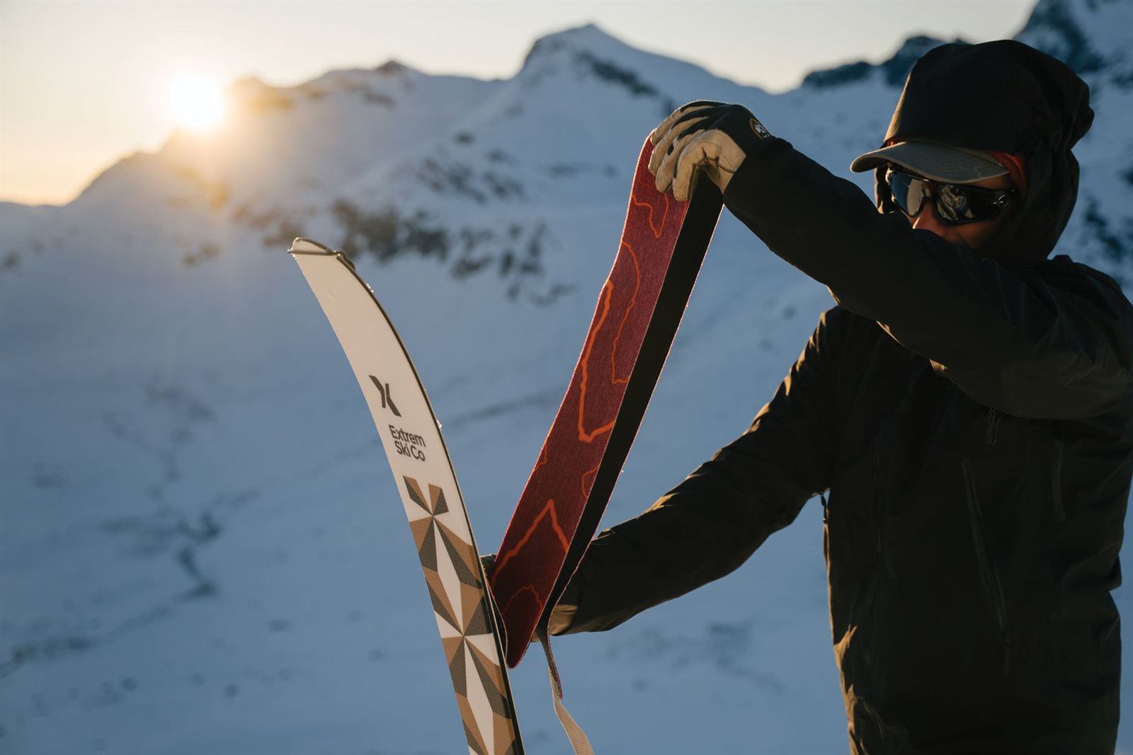 Fitting touring skins to a ski at sunrise on the mountain
